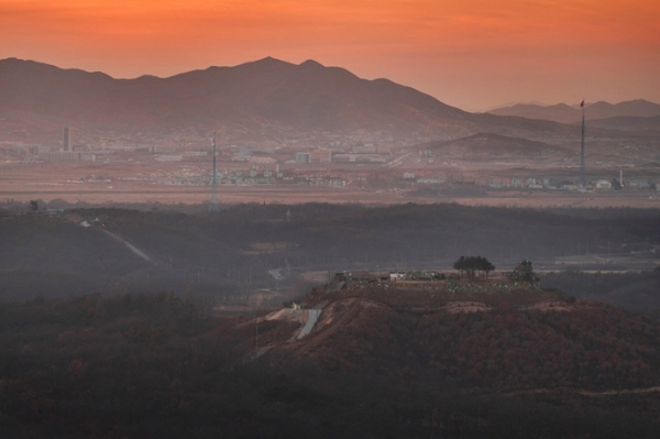 해 저무는 2018년 12월 경기도 파주시 접경지역에서 바라본 서부전선 DMZ 일대의 모습. GP 너머로 대성동 마을의 태극기와 기정동 마을의 인공기가 보이고 개성공단 일대에 평화로운 노을이 스며들고 있다. 연합출처 : 중부일보(http://www.joongboo.com)