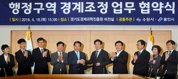 기형적인 시 경계로 7년간 갈등을 빚어온 수원시와 용인시가 주민불편 해소를 위해 합의했다. 백군기 용인시장과 염태영 수원시장이 협약서를 들고 기념촬영을 하고 있다./노경신 기자