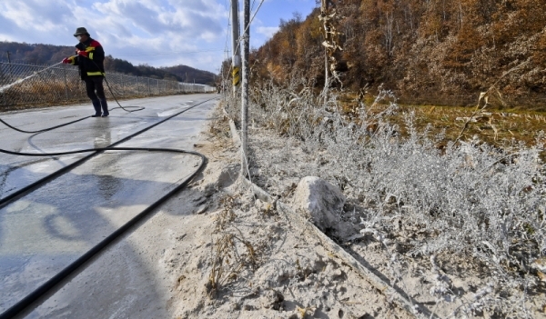 경기도 김포,파주,연천 세곳에서 아프리카 돼지열병(ASF) 추가 확산 방지를 위해 진행한 양돈 농장 비우기 작업을 완료된 11일 오후 연천군 중면 일원에서 방역관계자들이 매립지로 향하는 밭과 도로에 소독액을 뿌리고 있다. 윤원규기자