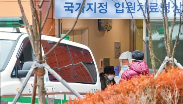 국내에서 네 번째 ‘우한 폐렴(신종 코로나바이러스 감염증)’ 확진 환자가 확인된 27일 오후 성남시 분당 서울대병원에서 한 우한 폐렴 의심환자가 방역복을 입은 관계자들과 국가지정 입원치료병상으로 입실하고 있다. 윤원규기자