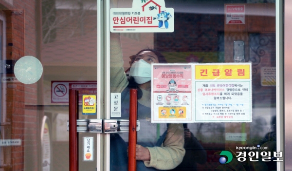 신종 코로나바이러스 감염증 네 번째 확진자 거주지인 평택지역의 어린이집과 유치원이 임시휴원에 돌입한 28일 오후 평택시 한 어린이집에서 선생님이 출입문을 잠그고 있다. /김금보기자