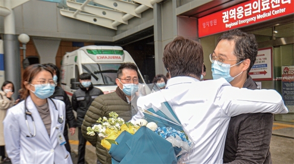 코로나19 국내 확진환자 중 3명이 완치판정을 받은 12일 오후 고양 명지병원에서 17번 확진자가 퇴원을 하며 의료진과 포옹하고 있다. 조주현기자