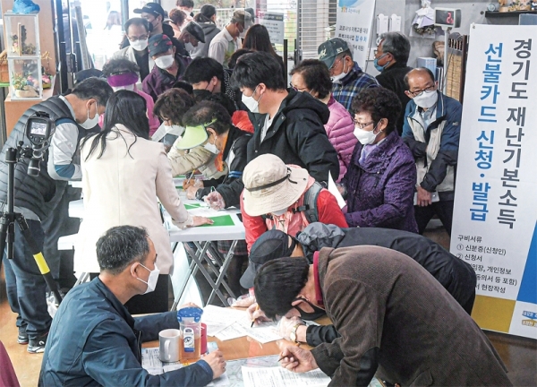 경기도 재난기본소득 현장 신청이 시작된 20일 오전 수원시 장안구 송죽동행정복지센터에서 주민들이 신청서류를 작성하고 있다. 경기도 재난기본소득 현장 신청은 신분증 지참 후 주소지 행정복지센터 또는 농•축협은행 영업점에서 가능하며, 온라인 신청은 관련 홈페이지를 통해 할 수 있다. 조주현기자