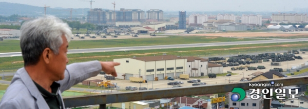 15년 전 평택 미군기지 이전으로 삶의 터전을 빼앗긴 이주민들에게 현재까지도 적절한 보상이 이뤄지지 않으면서 아픔이 이어지고 있다. 10일 황경회 미군기지 주변지역 이주민 비상대책위원장이 평택 캠프 험프리스로 변한 자신의 고향을 바라보고 있다. /김도우기자