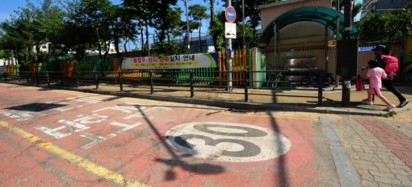 스쿨존에서 운전자의 안전 의무를 강화한 이른바 ‘민식이법’(도로교통법과 특정범죄가중처벌법 개정안)이 시행되고 있는 가운데 2일 수원의 한 초등학교 인근 어린이보호구역에서 한 초등학생이 부모님의 손을 잡고 등교하고 있다. /노경신기자