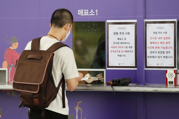 ▲ 신종 코로나바이러스 감염증(코로나19) 확산을 막기 위해 두 달 가까이 휴관한 수도권의 박물관·미술관·도서관 등 문화시설이 운영을 재개한 22일 오후 서울 용산구 국립중앙박물관을 찾은 시민이 전시표를 구매하고 있다. (사진=연합뉴스 제공)