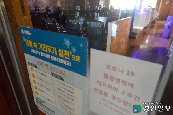 지난 18일 수원시의 한 PC방 입구에 영업중단 안내문이 붙어 있다. /김도우 기자