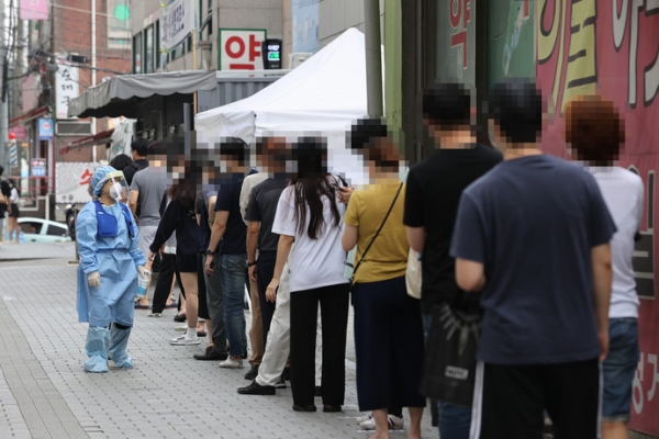 20일 오전 서울 성북구보건소에 마련된 신종 코로나바이러스 감염증(코로나19) 선별진료소를 찾은 시민들이 검사받기 위해 줄을 서고 있다. /연합
