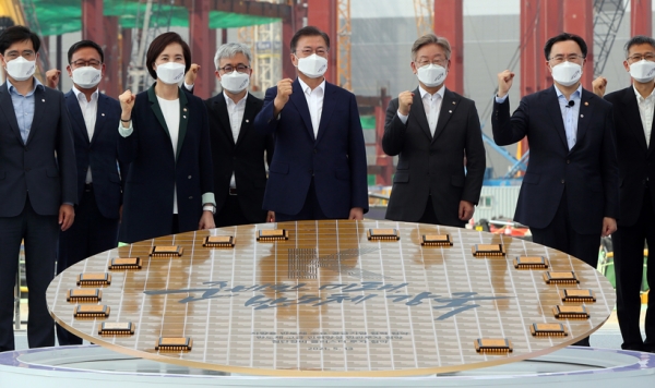 문재인 대통령이 13일 오후 경기 평택시 삼성전자 평택단지 3라인 건설현장에 마련된 야외무대에서 열린 'K-반도체 전략 보고'에서 '반도체 생태계 강화 연대 협력 협약식'을 마친 후 참석자들과 기념촬영을 하고 있다. /연합뉴스