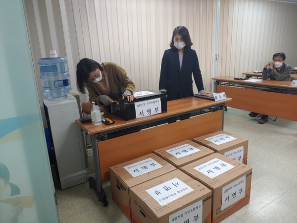 지난 3월 과천시장 주민소환을 위한 서명을 전달받은 과천시 선거관리위원회 직원들이 서명부 상자를 개봉하고 있는 모습. 사진=중부일보DB