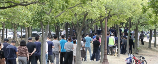 ▲ 외국인 밀집 지역인 안산시와 시흥시에서 최근 외국인 코로나19 확진자가 급증해 사업장에 대한 진단검사 행정명령을 내렸다. 첫날인 29일 오후 시흥시 정왕동 희망공원에 마련된 설별검사소에서 인근 반월·시화공단 근로자들이 햇볕을 피해 나무 그늘 밑으로 줄지어 기다리고 있다. /김철빈 기자