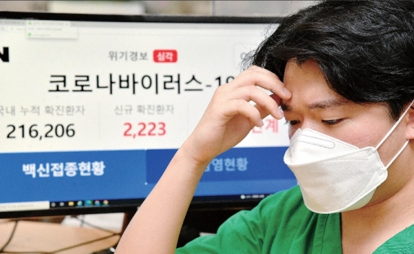 코로나19 신규 확진자 수가 2223명으로 사상 최대를 기록한 11일 오후 수원시 경기대학교 기숙사에 마련된 경기도 제14호 생활치료센터 상황실에서 관계자가 늘어난 입소자 관련 업무를 점검하며 심각한 표정을 짓고 있다. /김시범 기자