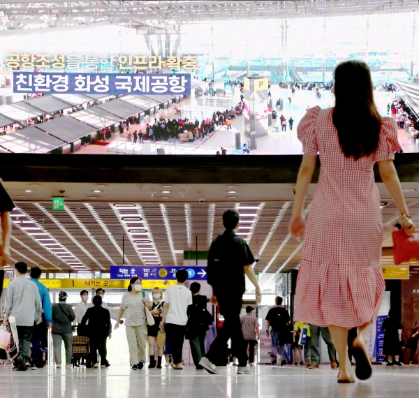 경기남부권 신공항 유치를 위해 수원시가 수원역 광고 스크린에 내건 '화성국제공항' 유치 홍보 영상물을 여행객들이 바라보고 있다./김철빈 기자