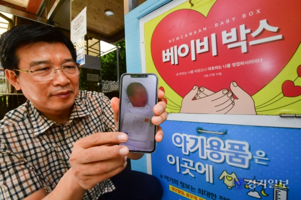 14일 오후 군포 새가나안교회 앞 베이비박스에서 이기동 목사가 과거 구조됐던 아동의 사진을 들어보이고 있다. 조주현 기자