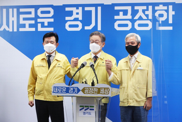 이재명 경기지사가 15일 도청 브리핑룸에서 경기도의회 더불어민주당 박근철 대표의원(왼쪽), 곽상욱 경기도시장군수협의회장(오른쪽)과 제3차 경기도 재난기본소득 지급 관련 기자회견을 마친 후 손을 맞잡고 있다. 경기사진공동취재단