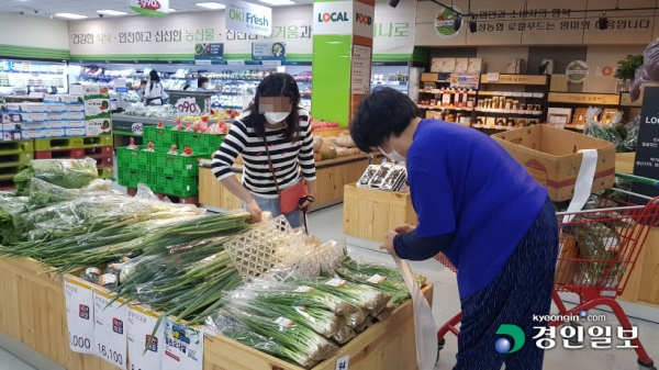 용인 구성농협 하나로마트 내부에 마련된 로컬푸드 직매장. 생산자(오른쪽)가 재배한 상품을 직접 포장해 매대에 진열하면, 소비자(왼쪽)는 막 도착한 신선한 상품을 곧바로 구매할 수 있는 장점을 갖췄다. 용인/황성규기자