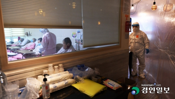 보호사가 코로나에 확진된 뒤 집단감염으로 이어진 수원영통종합요양센터에서 병상 부족으로 고령자가 숨지는 사고가 발생하는 등 의료공백이 커지고 있다. 9일 오전 이송을 기다리며 코호트 격리중인 수원영통종합요양센터에서 의료진이 확진자 환자들을 돌보고 있다. 2021.12.9 /임열수기자