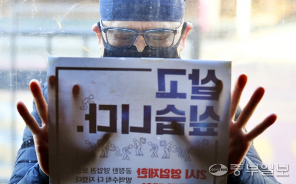 8일 오후 의왕시 한 음식점 업주가 영업시간 연장을 요구하는 포스터를 붙이고 있다. 정부는 사회적 거리두기 방역조치 조정방안에 따라 음식점 등 다중이용시설 영업제한시간을 비수도권에 한해 오후 10시까지로 1시간 완화한 가운데 수도권의 소상공인들의 반발이 심해지고 있다. /노민규 기자
