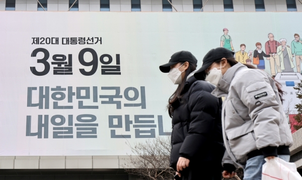 ▲ 제20대 대통령 후보 공식 선거운동을 하루 앞둔 14일 오전 수원시 영통구 경기도선거관리위원회 외벽에 설치된 투표독려 현수막 아래로 시민들이 지나가고 있다. /김철빈 기자