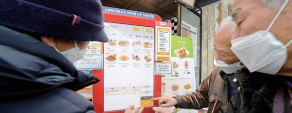 스마트폰,키오스크 등 디지털기기가 일상화 되면서 디지털문화에 익숙하지 않은 노인들이 어려움을 겪고 있다. 사진은 수원특례시 한 패스트푸드점에서 키오스크로음식을 주문하는 노인들. 윤원규 기자