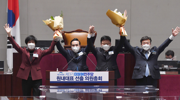 더불어민주당 박홍근 신임 원내대표가 24일 국회에서 열린 의원총회에서 새로운 원내대표로 선출된 뒤 꽃다발을 들어 올리고 있다. 오른쪽부터 윤호중 공동비상대책위원장, 박광온 의원, 박홍근 신임 원내대표, 김영주 선관위원장. (국회사진기자단)
