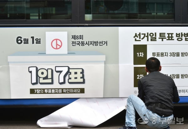 제8대 전국동시지방선거를 30일 앞둔 가운데 인천 중구 항동7가에 위치한 버스차고지에서 인천시선관위 관계자가 인천 시민의 발 시내버스에 선거 안내 홍보물을 부착하고 있다.정선식기자