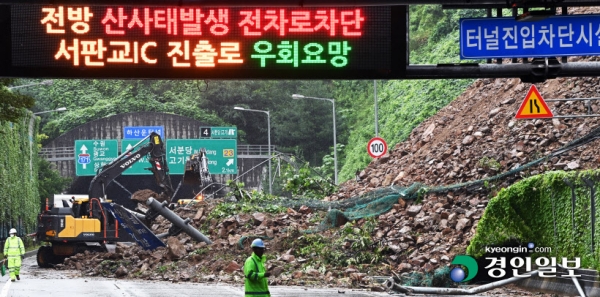 수도권 등 경기지역에 기록적인 폭우가 내린 9일 오전 성남시 분당구 용인서울고속도로 용인방면 하산운터널 입구 경사면 토사가 전날부터 내린 많은 비로 무너져 내려 긴급 복구작업을 벌이고 있다. /임열수 기자