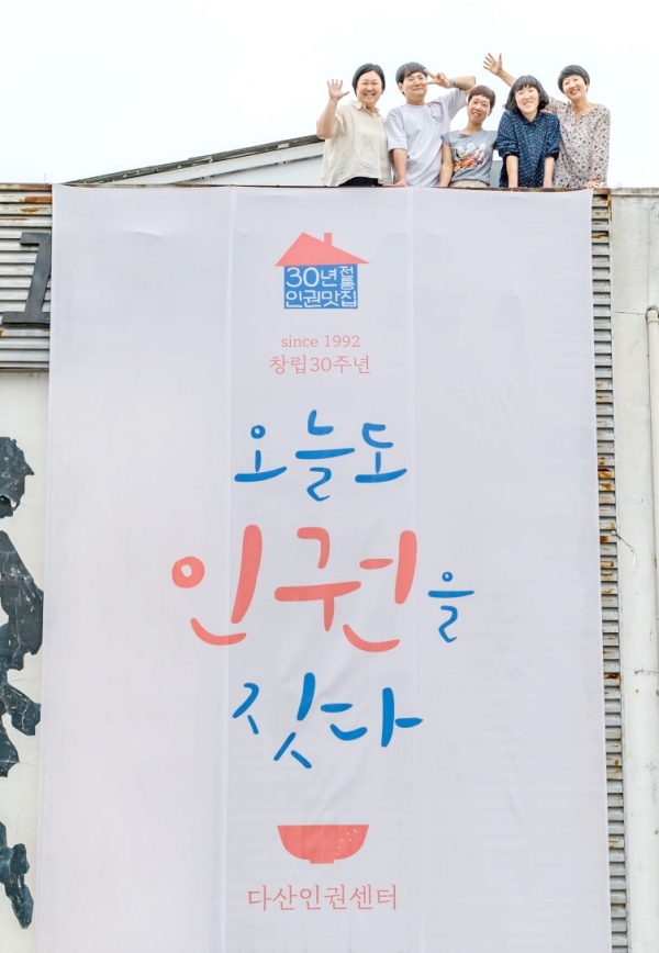 ▲ 다산인권센터 건물에 걸린 '오늘도 인권을 짓다' 현수막과 활동가들의 모습. /사진제공=다산인권센터