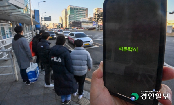 독과점 논란이 일던 카카오T를 견제하기 위해 경기도와 도내 시군 단위에서 만든 공공 호출앱이 저조한 이용률로 힘을 못쓰고 있다. 사진은 19일 오후 수원역 택시승강장에서 리본택시 어플 화면 뒤로 시민들이 택시에 탑승하고 있다. 2023.2.19. /김명년기