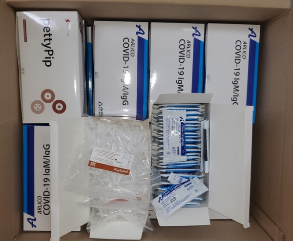 ▲ 경기도체육회가 8번가 위드팜약국으로부터 기증받아 경기도내 시·군체육회와 종목단체에 배포한 코로나19 항체진단키트와 채혈 튜브. 이 항체진단키트는 전문가용인데다 1박스가 키트 25개와 4.5㎖ 시약 1개로 구성돼 있어 개인적으로 사용하는데 어려움이 있다. (사진=유창현 기자)