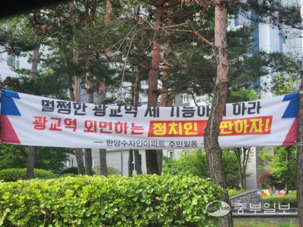 14일 오전 수원시 영통구 한 아파트 단지에 신분당선 연장 사업에 광교역 경유 등을 요구하는 한 지역 주민 단체의 현수막이 걸려 있다. 안시현기자