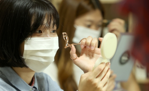 ▲ 수원의 한 대학교 동아리방에서 학생들이 수업에 들어가기 전 마스크를 착용한 채 눈 화장을 하고 있다. /김철빈 기자