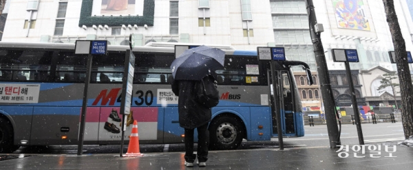 서울시가 명동에서 운영했던 '버스 줄서기 표지판'이 버스대란을 일으켜 시민들이 큰 불편을 겪은 가운데 시가 명동입구에 정차하는 경기도내 광역버스 30개 중 일부 노선 변경과 감차를 추진하고 있어 도민들의 출퇴근길 난항이 우려되고 있다. 9일 오전 서울시 중구 명동입구 버스정류장에서 한 시민이 광역버스를 기다리고 있다. 2024.1.9 /이지훈기자