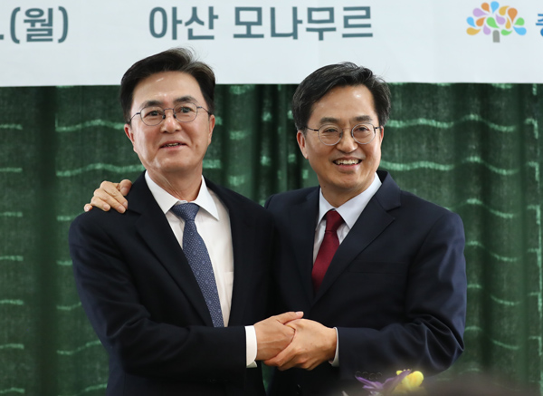 지난해 3월 13일 충남 아산시 복합문화공간 모나무르에서 열린 '베이밸리 메가시티 세미나'에서 김태흠(왼쪽) 충남지사와 김동연(오른쪽) 경기지사가 손을 맞잡고 있다./연합뉴스