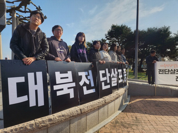 31일 파주시 문산읍 국립6·25납북자기념관 앞에서 열린 대북전단 살포 중단 촉구 집회에서 참가자들이 ‘대북전단 살포 중단’이라 쓰인 팻말을 들고 있다.