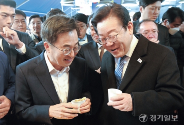 더불어민주당 이재명 대표(오른쪽)와 김동연 경기도지사가 21일 오전 수원특례시 못골시장을 찾아 호떡을 먹으며 대화하고 있다. 윤원규 기자