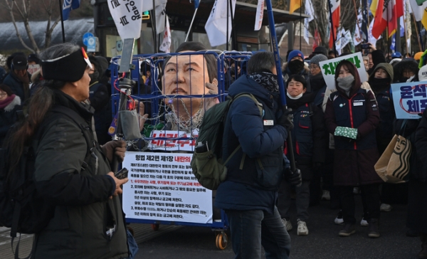 22일 오후 서울 서초구 남태령 부근에서 한남동 대통령 관저를 향하다 경찰차벽에 막혀 대치중인 전국농민회총연맹의 트랙터 집회에서 체포된 모습의 윤석열 대통령 인형이 배치돼 있다.  (사진=옥지훈 기자)