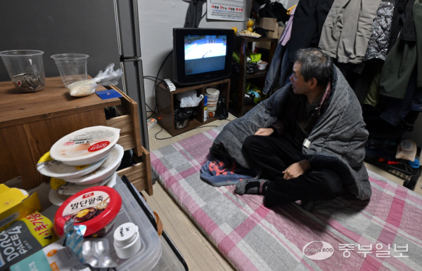 본격적인 겨울 맹한파가 도래하며 복지사각지대에 대한 우려가 커지는 가운데 9일 오후 수원시 남수동 쪽방촌에서 한 시민이 웃옷을 입고 이불을 덮은 채 TV를 시청하고 있다. 김경민기자